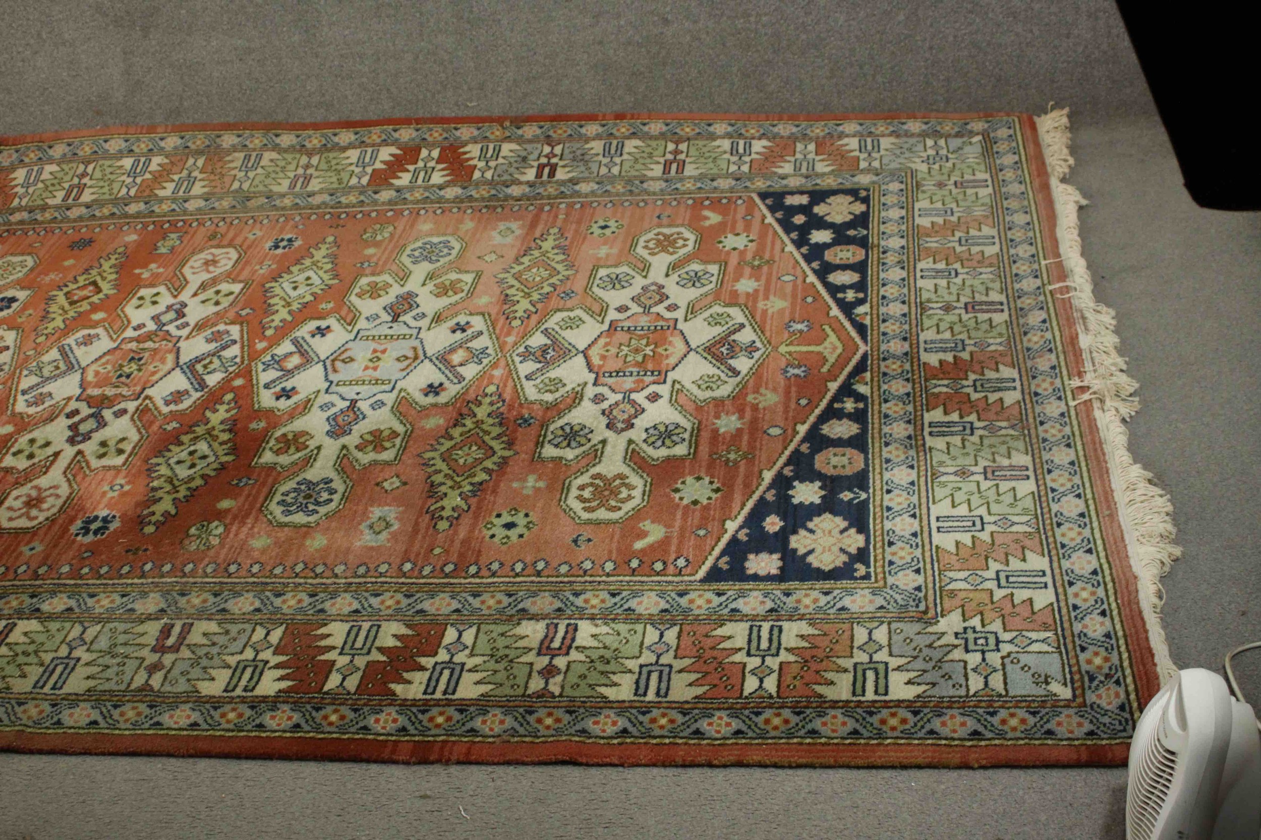 A Caucasian motif carpet with repeating stylised motifs on a terracotta field within geometric - Image 3 of 6