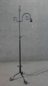 A Victorian style wrought iron adjustable standard lamp, on tripod feet with scroll ends. H.160cm