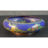 A Meji period Japanese cloisonné enamel flower design on blue ground bowl. Cloud design to the base.