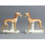 A pair of Victorian Staffordshire pottery Greyhounds with Hares. 15.2 cm. UK Postage £15.