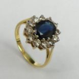 18ct Sapphire and Diamond cluster ring, Birmingham 1976, 3.8 grams. Size N 1/2, 14.2 mm wide. UK