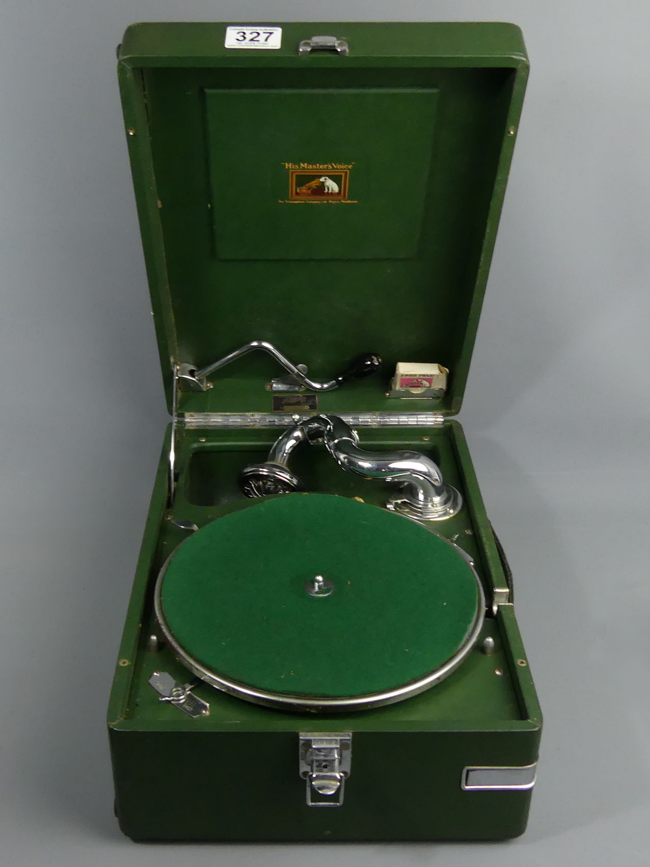 H.M.V green cased table top wind-up gramophone, retailed by Harods, with some 78's. UK Postage £20.