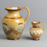 A Doulton Lambeth water jug depicting the seasons, dated 1884 and a Doulton Lambeth mask head jug.