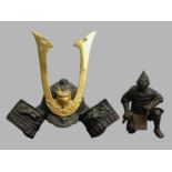 A Japanese metal wares figure of a Samurai warrior and a model of a Samurai helmet. Helmet 18.5