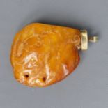 A carved elephant design Chinese butterscotch amber, gold mounted pendant. 14 grams.54 x 39 mm. UK