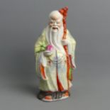 Chinese famille rose porcelain figure of an elder holding a peach. 22 cm. UK Postage £14.