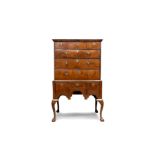 A QUEEN ANNE FIGURED WALNUT CHEST ON STAND