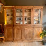 A 19TH CENTURY MAHOGANY BREAKFRONT BOOKCASE WITH CAMPAIGN DRAWERS