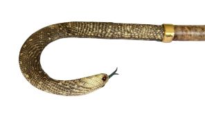 A TAXIDERMY LIZARD SKIN AND SNAKE HEAD HANDLED WALKING CANE