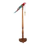 A TAXIDERMY MACAW PARROT MOUNTED ON A STANDARD LAMP