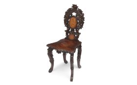 A LATE 19TH CENTURY BLACK FOREST CARVED WOOD HALL CHAIR