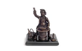 A REGENCY BRONZE PEN HOLDER IN THE FORM OF A JOVIAL GENTLEMAN