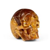 A CARVED AMBER MODEL OF A SKULL, MIOCENE PERIOD (23 MILLION YEARS OLD)