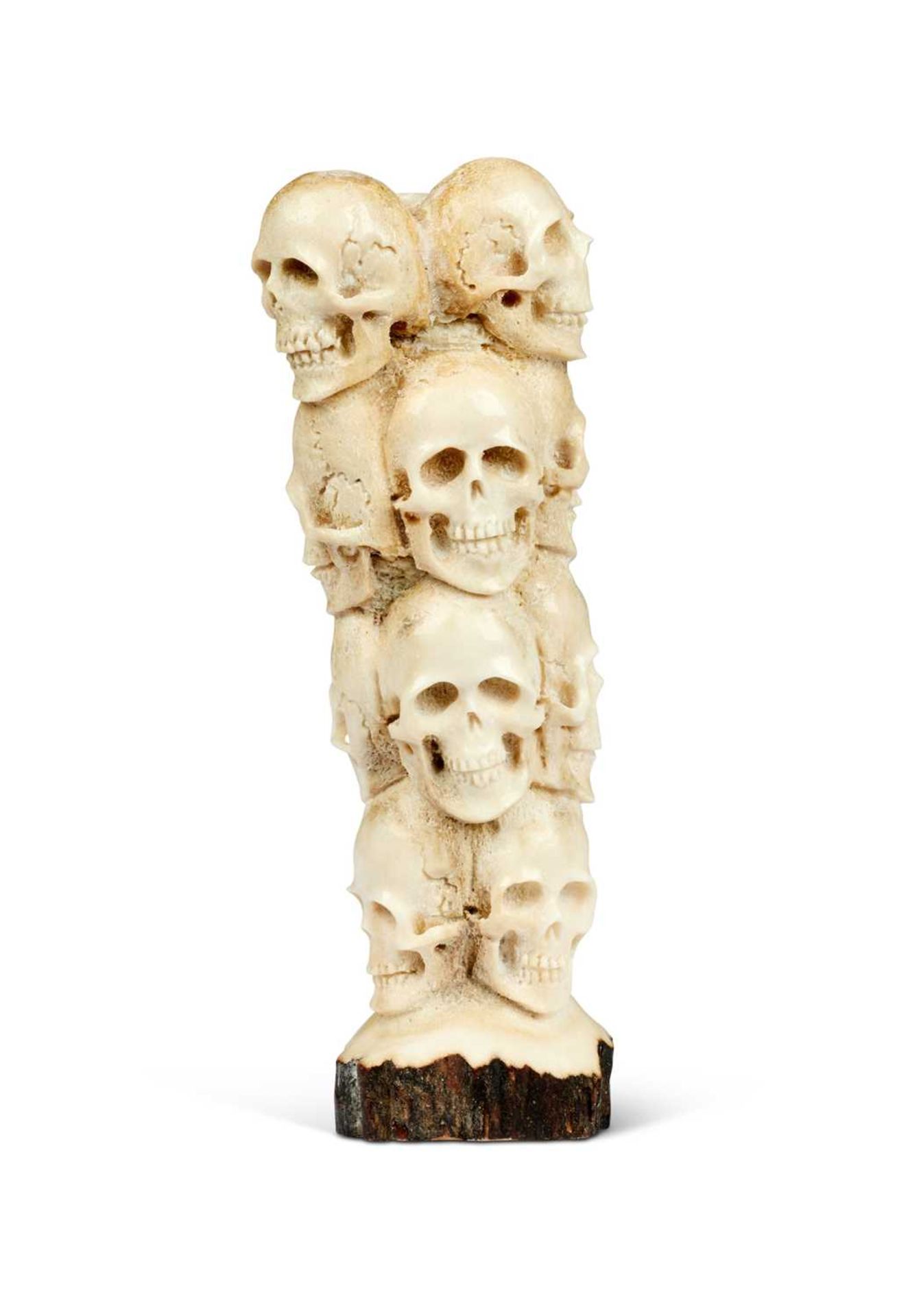 A CARVED ANTLER MEMENTO MORI IN THE FOMR OF TWELVE HUMAN SKULLS