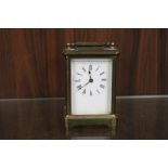 AN ANTIQUE FRENCH BRASS AND GLASS CARRIAGE CLOCK