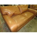 A TAN LEATHER TWO SEATER SOFA -SIGNS OF WEAR