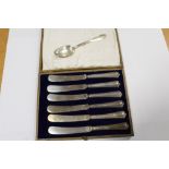 A CASED SET OF SIX SILVER HANDLED BUTTER KNIVES TOGETHER WITH AN 800 SILVER TEASPOON STAMPED