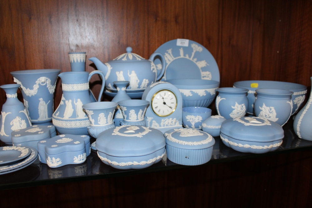 A LARGE QUANTITY OF BLUE WEDGWOOD JASPERWARE TO INCLUDE A TEAPOT, FRUIT BOWL, MANTEL CLOCK ETC. (