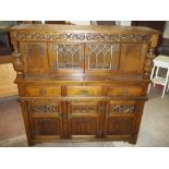 AN OAK COURT CUPBOARD WITH LINENFOLD AND PINEAPPLE DETAILING