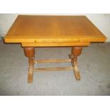 A VINTAGE OAK DRAWER LEAF DINING TABLE WITH SLIGHTLY CHEWED FEET