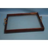 A MAHOGANY FRAMED GLASS TRAY WITH BRASS HANDLES