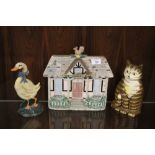 THREE CAST METAL DOORSTOPS IN THE FORMS OF A CAT, A DUCK AND A COTTAGE