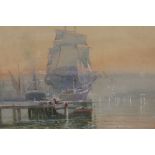 WILFRED KNOX - AN OAK FRAMED AND GLAZED WATERCOLOUR DEPICTING A DOCKLAND SCENE WITH BOATS AND