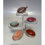 A SELECTION OF FOUR SILVER AND POLISHED AGATE PENDANTS, tallest 6.5 cm including bail, together with