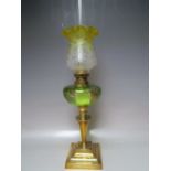 A LATE NINETEENTH / EARLY TWENTIETH CENTURY CONTINENTAL BRASS OIL LAMP, with green glass reservoir