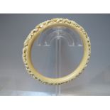 AN ANTIQUE CARVED IVORY BANGLE, internal Dia. 8.1 cm