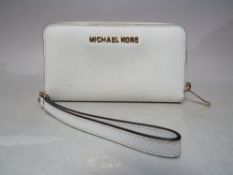 A LARGER MICHAEL KORS WINTER WHITE PURSE, complete with wrist strap, single zip closure, W 18 cm,