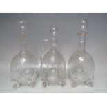 A SET OF THREE THOMAS WEBB LION MASK DECANTERS, with extensive engraved decoration throughout, to