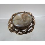 A UNUSUAL ANTIQUE MOURNING BROOCH, having central oval rotating panel set with agate one side and