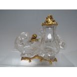 AN ORIENTAL ROCK CRYSTAL GROUP OF A WINGED BEAST COILED AROUND A TWIN HANDLED VASE WITH GILT