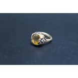 AN UNUSUAL DRESS RING WITH THE SETTING IN THE FORM OF A FRUITING VINE, set with a yellow citrine