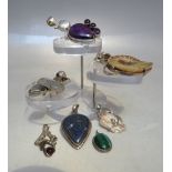 A SELECTION OF ASSORTED SILVER PENDANTS, to include a polished ammonite example, tallest 6.2 cm (7)