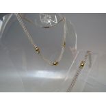 A MODERNIST SILVER AND 14 CT GOLD NECKLACE AND BRACELET SET, the silver beaded effect design