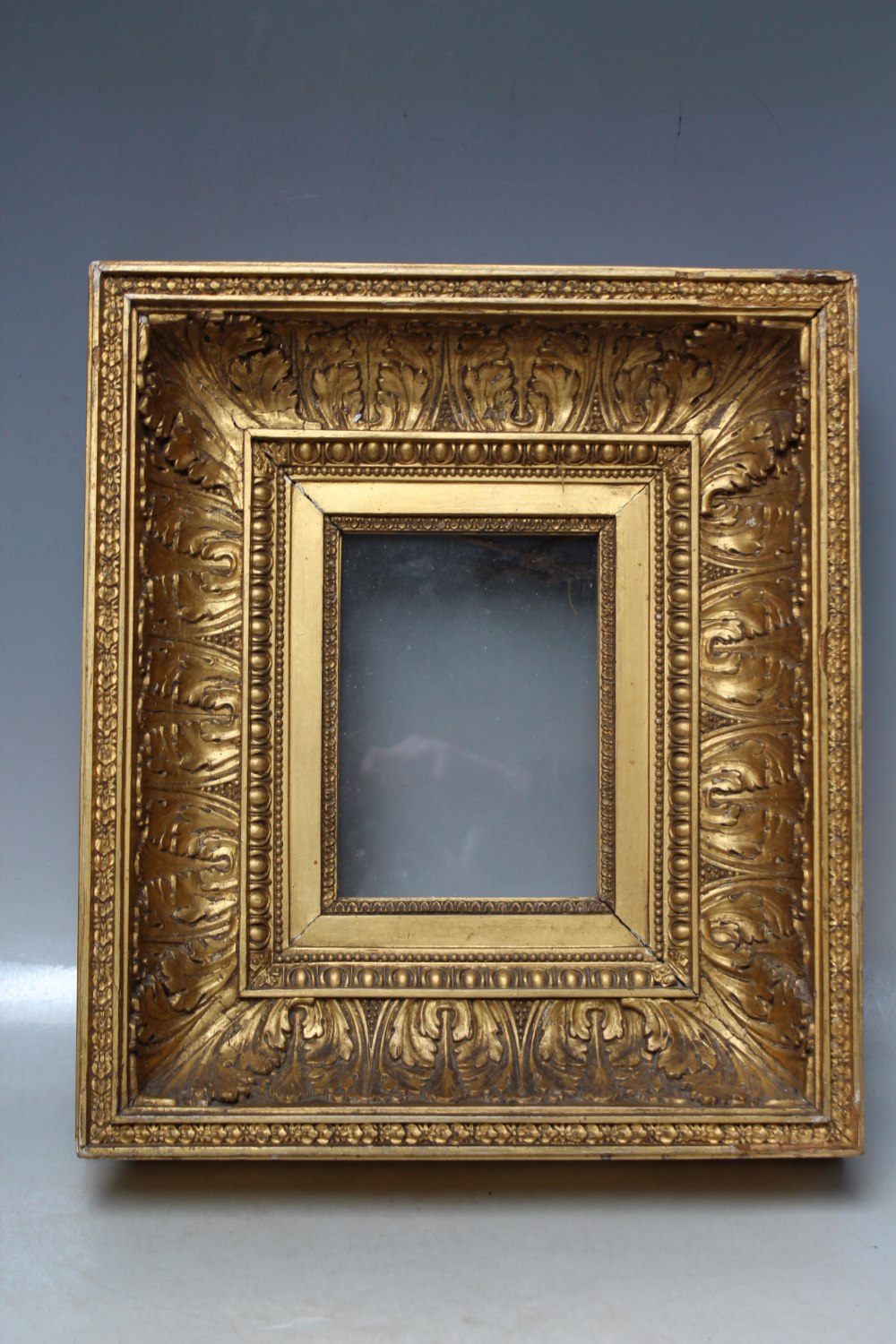 A LATE 18TH / EARLY 19TH CENTURY DECORATIVE GOLD FRAME, with acanthus leaf design and integral