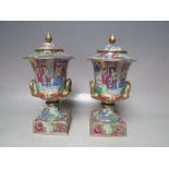 A PAIR OF FAMILLE ROSE LIDDED CAMPANA URNS ON STANDS, with profuse figural, floral and foliate