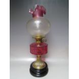 A VICTORIAN BRASS OIL LAMP, with ruby glass reservoir, etched glass shade, H 55 cm
