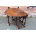 AN ANTIQUE OAK DROPLEAF DINING TABLE, with typical gateleg mechanism, Dia. 125 cm