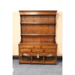 A 20TH CENTURY OAK TRADITIONAL DRESSER OF SMALL PROPORTIONS, the enclosed rack over a base with