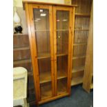 A MODERN PINE GLAZED TWO DOOR BOOKCASE H-188 W-83 CM