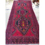 A LARGE PERSIAN WOOLLEN RUG 301 X 140 CM