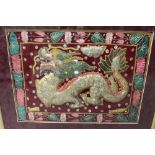 A FRAMED AND GLAZED ORIENTAL STYLE NEEDLEWORK OF A DRAGON, TOGETHER WITH A PRINT OF A WARRIOR ON