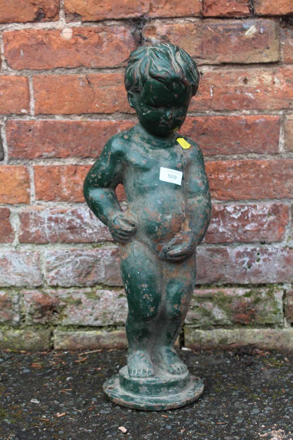 A VINTAGE CAST IRON FIGURE OF A YOUNG BOY