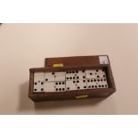 A WOODEN BOX OF DOMINOES