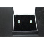 A PAIR OF 9CT GOLD EARRINGS SET WITH AQUAMARINE COLOURED STONES