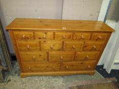 A MODERN HONEY PINE FOURTEEN DRAWER CHEST W-131 CM