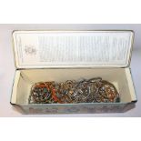 A TIN OF COSTUME JEWELLERY